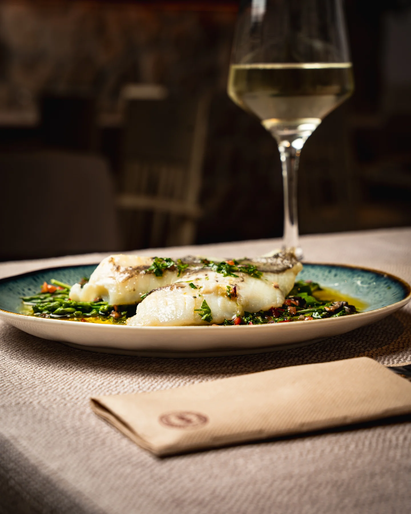 Plato de Ca Nostra servido junto a una copa de vino